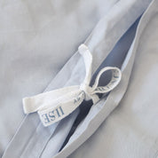 Subtle details such as soft corner stitching and delicate bow fasteners offer a sense of quiet luxury, combining effortless function with elegant finishing.