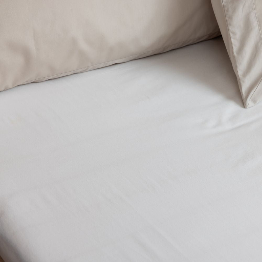 Close-up of beige bedding on a bed with a Sand beige fitted sheet